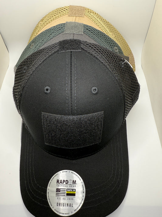 Three baseball caps of different colors stacked on a white surface with a visible brand label.